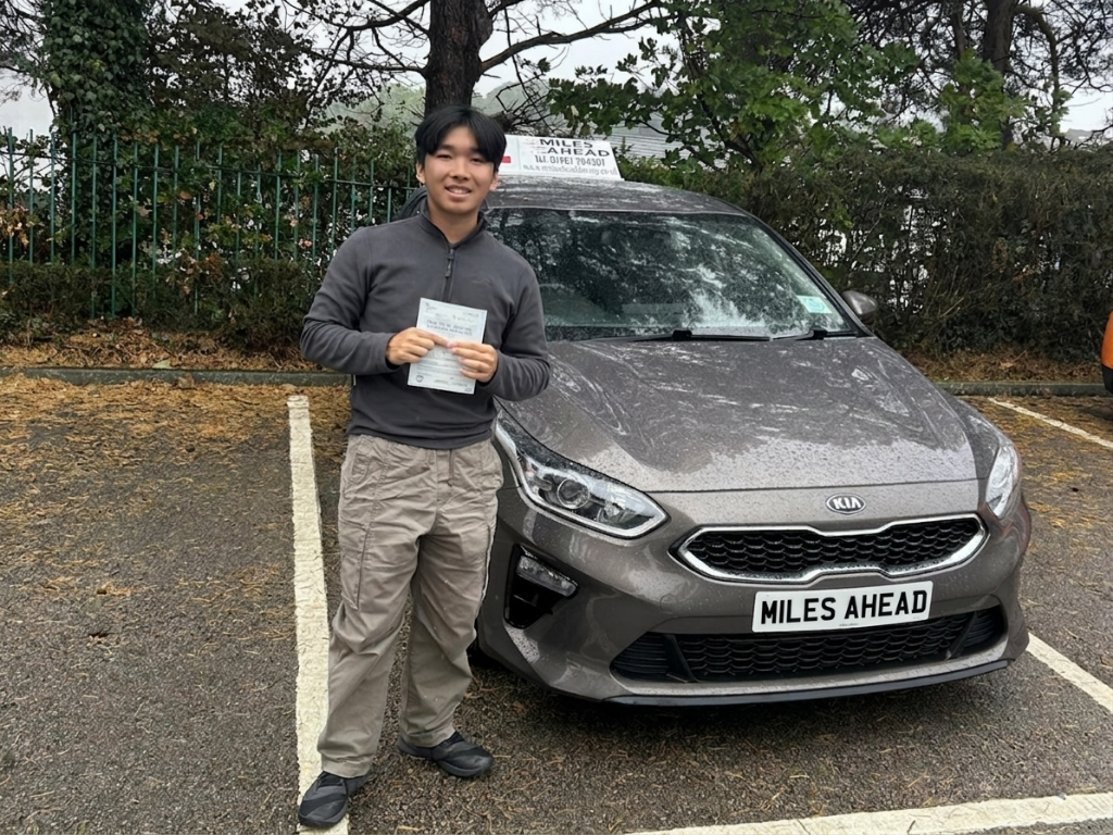 student of miles ahead driving school holding pass certificate in front of learner car